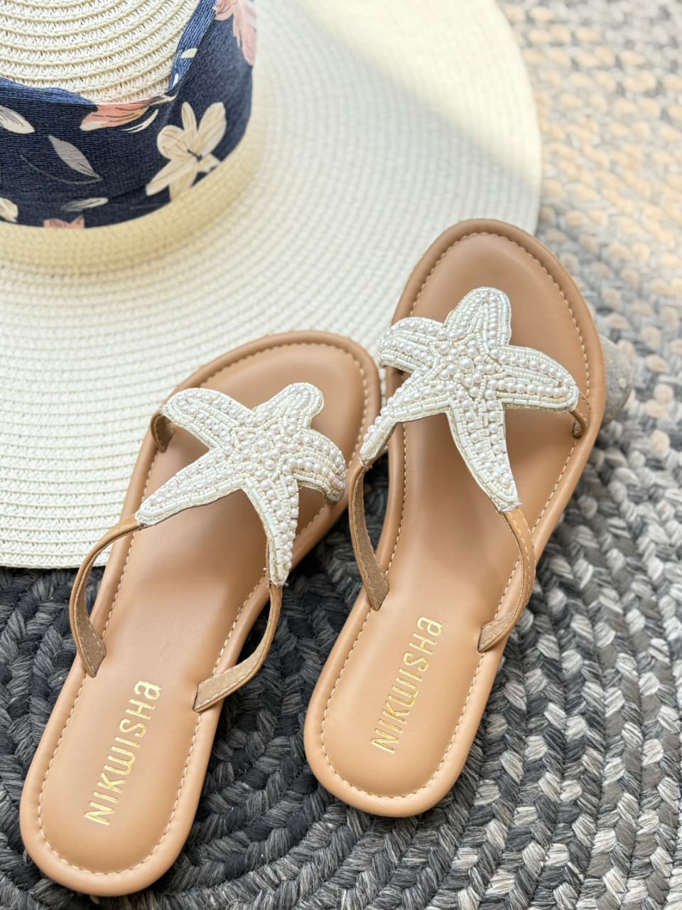 Pair of sandals with starfish designs on a faux leather surface